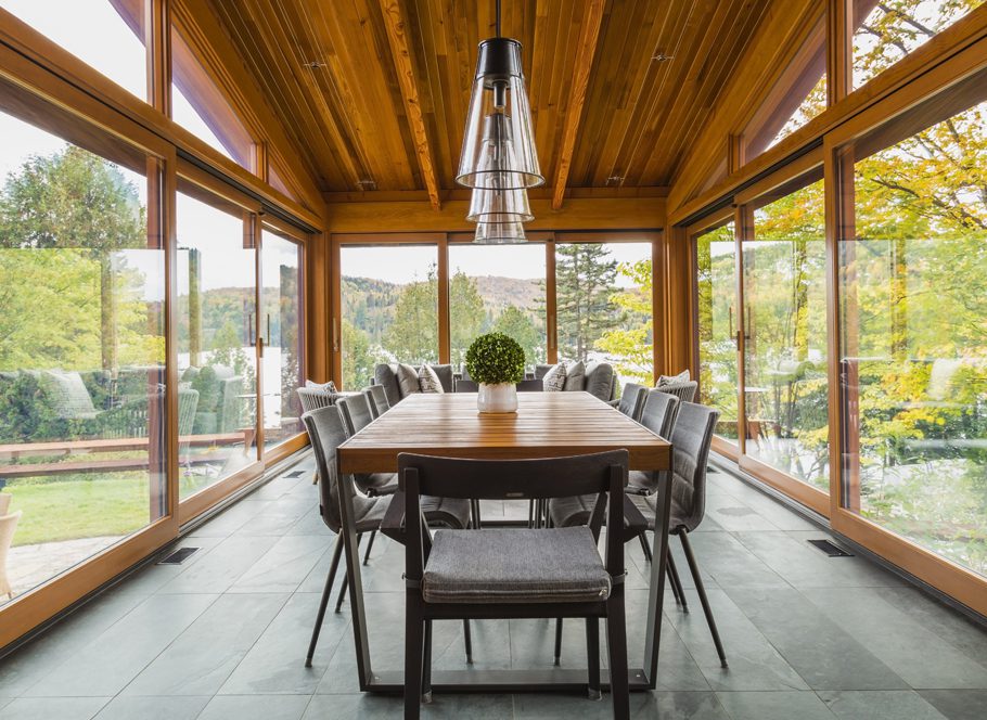 A K Construction | Lake Toxaway, NC | glass sunroom with large dining table and seating area